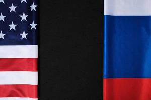 Flags of the United States of America and the Russian Federation are opposite each other on a black background.