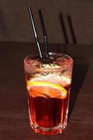 refreshing cocktail with a straw, ice cubes and a slice of lemon photo