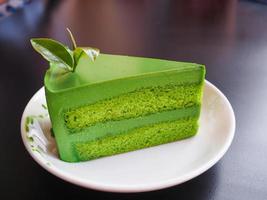 pastel de té verde en plato blanco y fondo negro foto