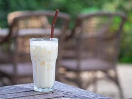 Side view of white chocolate cold in the glass on wooden table photo