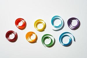 Rainbow colored paper circles on white background photo