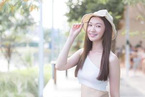 Young Asian beautiful woman with  good skin in cream shirt standing smiling happily on blurred background. photo