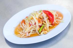 Papaya salad is a spicy salad made from shredded unripe papaya. Originating from ethnic Lao people, it is also eaten throughout Southeast Asia. It is Thai style food. photo