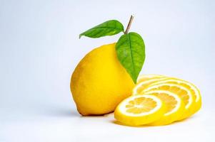 la rodaja de limón y limón en el fondo blanco