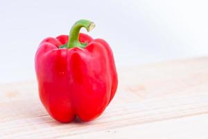 Colorful peppers placed on a wooden table photo