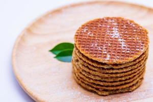 Wafer sprinkled with powder on wooden tray ready to serve