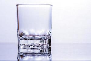 Glass of whiskey on a glass table photo