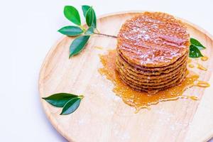 Wafer sprinkled with honey on wooden tray ready to serve photo