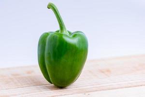 Colorful peppers placed on a wooden table photo