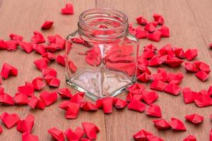 jar of empty paper hearts on a wooden table. photo