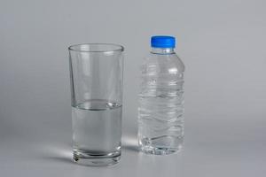 Glass and bottle with half water. photo
