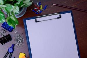 File, pencil and office supplies. Placed beside a tree on a wooden table. photo