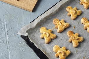 sabrosas galletas navideñas caseras, galletas de anacardo recién horneadas en forma de muñeca en la mesa foto