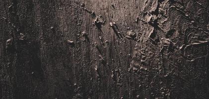 Wall full of scratches. Grungy cement texture for background, Scary dark wall.Black wall photo