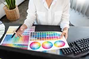 interior designer or creative graphic designer working on project architectural with colour samples with work tools and equipment for selection in office photo