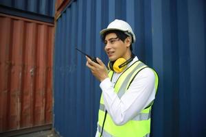 Foreman control loading Containers box from Cargo freight ship for import export. photo