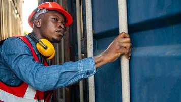 Engineer or supervisor checking and control loading Containers box from Cargo at harbor. Foreman control Industrial Container Cargo freight ship at industry. Transportation and logistic concept. photo