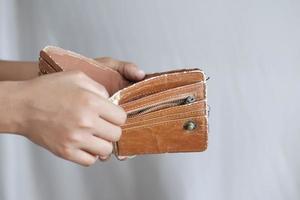 La mano del hombre abre una billetera vacía con espacio de copia.