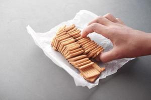 top view of sweet cookies in a plastic packet on wooden table photo