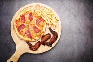 Slice of cheese pizza on a plate on wooden table. photo