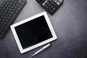 Flat composition of digital tablet and office stationary on black background photo