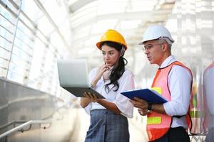 The engineer and business woman checking on clipboard at construction site building. The concept of engineering, construction, city life and future. photo