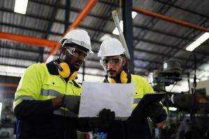 Maintenance Engineers is working in front of the automated CNC machinery repair on a maintenance checklist at the production line. photo