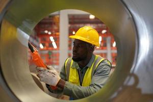 Men industrial engineer wearing a safety helmet while standing in a heavy industrial factory. The Maintenance looking of working at industrial machinery and check security system setup in factory. photo