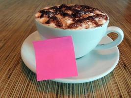Pink note on coffee cup. Copy space. For text or messages purpose. photo