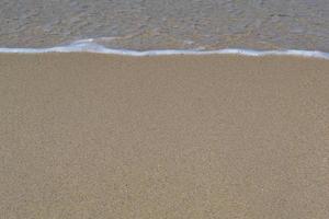 Soft wave of blue ocean on sandy beach. Background. photo