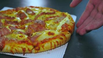 Pizza de chorizo y jamón con queso. la pizza en la caja de entrega diaria fue entregada sobre la mesa de mármol.