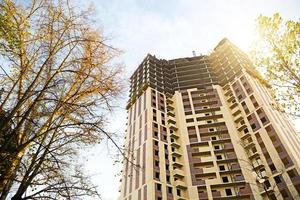 Construction of a multi-storey apartment building in the city. A crane near a skyscraper. Building, moving to a new flat, mortgage, rent and purchase real estate. Copy space photo