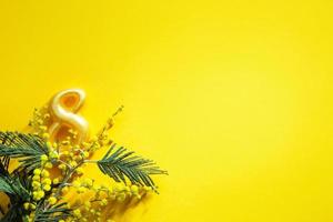 un ramo de mimosa y el número 8 sobre un fondo amarillo con copyspace es una tarjeta de felicitación para el día internacional de la mujer el 8 de marzo. día de la independencia de la mujer. festival de primavera, primavera foto