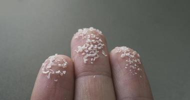 Close up side shot of microplastics on human fingers. Concept for water pollution and global warming.  Climate change idea. Soft focus on bunch of micro plastic that cannot be recycled. photo