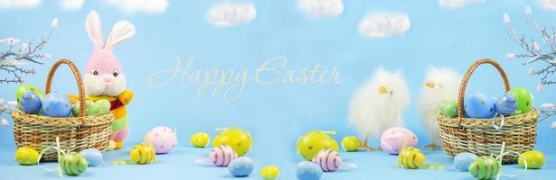 Pascua de Resurrección. tarjeta de pascua feliz con huevos de pascua tradicionales en una canasta y un conejo. letras felices pascuas. pollos bandera. copie el espacio foto