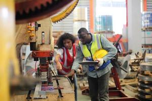 el capataz de los trabajadores de la industria o el trabajo de los trabajadores en el sitio de la fábrica revisan la máquina o los productos en el sitio. ingeniero o técnico revisando material o máquina en planta. industrial y fábrica. foto