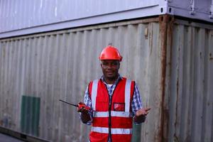 Engineer or supervisor checking and control loading Containers box from Cargo at harbor. Foreman control Industrial Container Cargo freight ship at industry. Transportation and logistic concept. photo