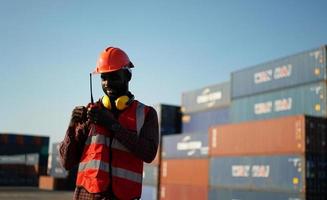 Foreman control loading Containers box from Cargo freight ship for import export. photo