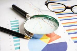 Magnifying glass on charts graphs paper. Financial development, Banking Account, Statistics, Investment Analytic research data economy. photo