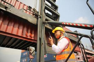 trabajador de la industria controla la carga de contenedores en la terminal de contenedores foto