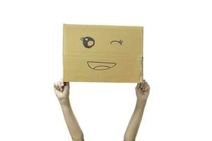 Child hand holding a cardboard box with smiley face isolated on white background. with clipping path. photo