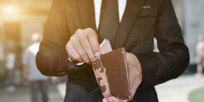 Businessman hand holding open leather wallet with cash. business and finances concept. photo