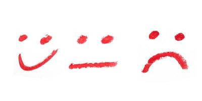 smiley face and sad drawing with red lipstick on white background. photo