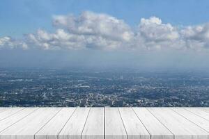 mesa de madera blanca sobre fondo de vista de la ciudad. para exhibición de productos o montaje. foto