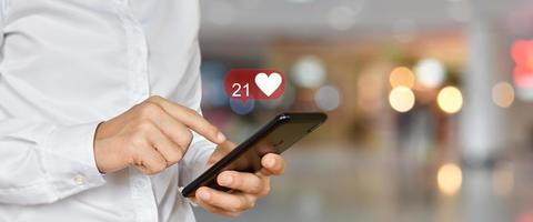 Close up of man using mobile smartphone with social, media icons. Marketing or business technology concept. photo