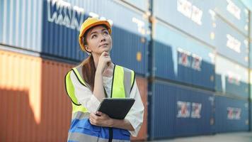 Trabajadora de la industria que controla la carga de contenedores en la terminal de contenedores foto