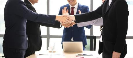 gente de negocios dándose la mano en la oficina moderna terminando una reunión exitosa foto