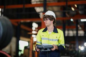 engineer checking control panel and teaching new Automatics robot arm and operating control machine in factory. photo