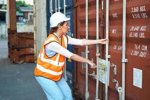 Foreman control loading Containers box from Cargo freight ship for import export. photo