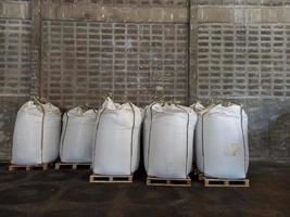 gran saco de cáñamo jumbo blanco, lleno de fertilizante químico, arroz, azúcar, colocado en un palé de madera a la espera de ser entregado al cliente
